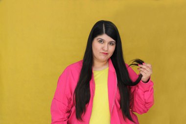 Uzun düz saçlı, 30 yaşındaki Latin bir kadın kuru, hasarlı saçları ve kırık uçlarıyla tatmin olmuyor ve hayal kırıklığına uğruyor.