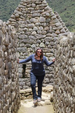 30 yaşındaki Latin bir kadın Cusco, Peru 'daki Machu Picchu arkeolojik alanını keşfediyor, selfie çekiyor ve turist olarak tatilinin tadını çıkarıyor.