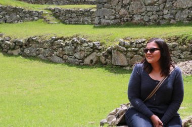 30 yaşındaki Latin bir kadın Cusco, Peru 'daki Machu Picchu arkeolojik alanını keşfediyor, selfie çekiyor ve turist olarak tatilinin tadını çıkarıyor.