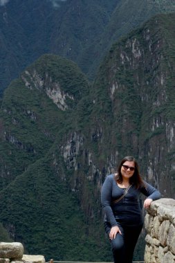 30 yaşındaki Latin bir kadın Cusco, Peru 'daki Machu Picchu arkeolojik alanını keşfediyor, selfie çekiyor ve turist olarak tatilinin tadını çıkarıyor.