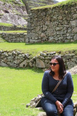 30 yaşındaki Latin bir kadın Cusco, Peru 'daki Machu Picchu arkeolojik alanını keşfediyor, selfie çekiyor ve turist olarak tatilinin tadını çıkarıyor.