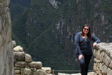 30 yaşındaki Latin bir kadın Cusco, Peru 'daki Machu Picchu arkeolojik alanını keşfediyor, selfie çekiyor ve turist olarak tatilinin tadını çıkarıyor.