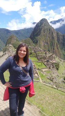 30 yaşındaki Latin bir kadın Cusco, Peru 'daki Machu Picchu arkeolojik alanını keşfediyor, selfie çekiyor ve turist olarak tatilinin tadını çıkarıyor.