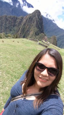 30 yaşındaki Latin bir kadın Cusco, Peru 'daki Machu Picchu arkeolojik alanını keşfediyor, selfie çekiyor ve turist olarak tatilinin tadını çıkarıyor.