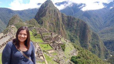 30 yaşındaki Latin bir kadın Cusco, Peru 'daki Machu Picchu arkeolojik alanını keşfediyor, selfie çekiyor ve turist olarak tatilinin tadını çıkarıyor.