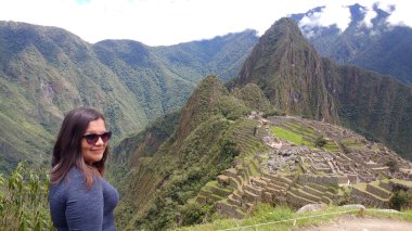 30 yaşındaki Latin bir kadın Cusco, Peru 'daki Machu Picchu arkeolojik alanını keşfediyor, selfie çekiyor ve turist olarak tatilinin tadını çıkarıyor.