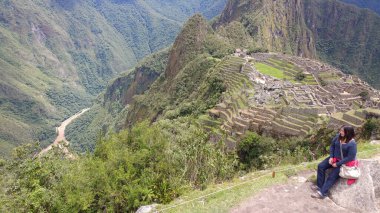 30 yaşındaki Latin bir kadın Cusco, Peru 'daki Machu Picchu arkeolojik alanını keşfediyor, selfie çekiyor ve turist olarak tatilinin tadını çıkarıyor.