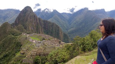 30 yaşındaki Latin bir kadın Cusco, Peru 'daki Machu Picchu arkeolojik alanını keşfediyor, selfie çekiyor ve turist olarak tatilinin tadını çıkarıyor.