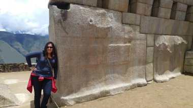 30 yaşındaki Latin bir kadın Cusco, Peru 'daki Machu Picchu arkeolojik alanını keşfediyor, selfie çekiyor ve turist olarak tatilinin tadını çıkarıyor.