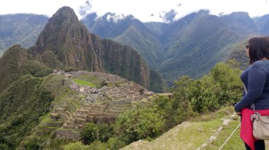 30 yaşındaki Latin bir kadın Cusco, Peru 'daki Machu Picchu arkeolojik alanını keşfediyor, selfie çekiyor ve turist olarak tatilinin tadını çıkarıyor.