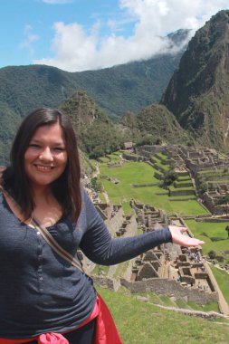 30 yaşındaki Latin bir kadın Cusco, Peru 'daki Machu Picchu arkeolojik alanını keşfediyor, selfie çekiyor ve turist olarak tatilinin tadını çıkarıyor.