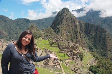 30 yaşındaki Latin bir kadın Cusco, Peru 'daki Machu Picchu arkeolojik alanını keşfediyor, selfie çekiyor ve turist olarak tatilinin tadını çıkarıyor.
