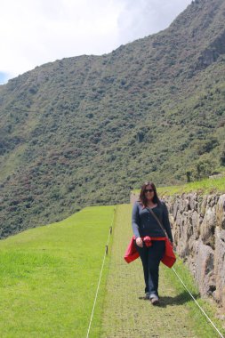 30 yaşındaki Latin bir kadın Cusco, Peru 'daki Machu Picchu arkeolojik alanını keşfediyor, selfie çekiyor ve turist olarak tatilinin tadını çıkarıyor.