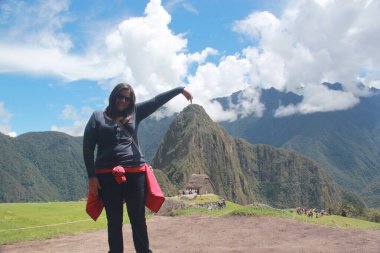 30 yaşındaki Latin bir kadın Cusco, Peru 'daki Machu Picchu arkeolojik alanını keşfediyor, selfie çekiyor ve turist olarak tatilinin tadını çıkarıyor.