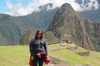 30 yaşındaki Latin bir kadın Cusco, Peru 'daki Machu Picchu arkeolojik alanını keşfediyor, selfie çekiyor ve turist olarak tatilinin tadını çıkarıyor.