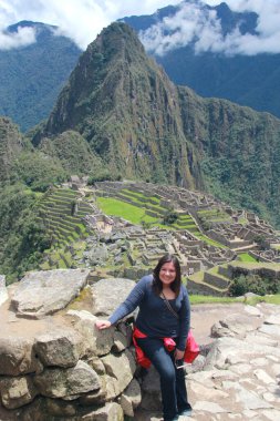 30 yaşındaki Latin bir kadın Cusco, Peru 'daki Machu Picchu arkeolojik alanını keşfediyor, selfie çekiyor ve turist olarak tatilinin tadını çıkarıyor.