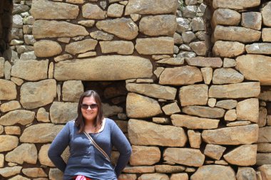 30 yaşındaki Latin bir kadın Cusco, Peru 'daki Machu Picchu arkeolojik alanını keşfediyor, selfie çekiyor ve turist olarak tatilinin tadını çıkarıyor.