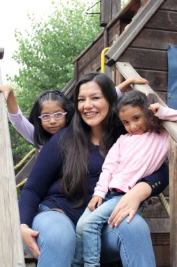 Boşanmış bekar anne ve iki esmer Latin kız çocuk parkında oynuyorlar ve anneler gününü birlikte kutluyorlar.