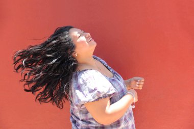 25 yaşında kıvırcık saçlı ve çalışan esmer bir kadın mutlu, güçlü, bağımsız ve güçlü görünüyor.