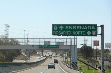 Ensenada, Baja California, Meksika - 14 Aralık 2025: Meksika 'da Tijuana' dan Ensenada Baja California 'ya giden Panoramik Karayolu üzerindeki yol işaretleri yön ve mesafeyi veya çıkışları gösteriyor