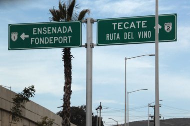 Ensenada, Baja California, Meksika - 14 Aralık 2025: Meksika 'da Tijuana' dan Ensenada Baja California 'ya giden Panoramik Karayolu üzerindeki yol işaretleri yön ve mesafeyi veya çıkışları gösteriyor