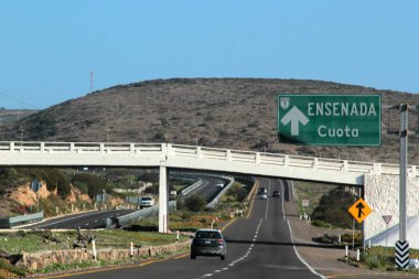 Ensenada, Baja California, Meksika - 14 Aralık 2025: Meksika 'da Tijuana' dan Ensenada Baja California 'ya giden Panoramik Karayolu üzerindeki yol işaretleri yön ve mesafeyi veya çıkışları gösteriyor