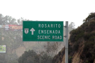 Ensenada, Baja California, Meksika - 14 Aralık 2025: Meksika 'da Tijuana' dan Ensenada Baja California 'ya giden Panoramik Karayolu üzerindeki yol işaretleri yön ve mesafeyi veya çıkışları gösteriyor