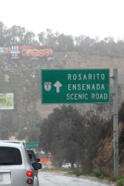 Ensenada, Baja California, Meksika - 14 Aralık 2025: Meksika 'da Tijuana' dan Ensenada Baja California 'ya giden Panoramik Karayolu üzerindeki yol işaretleri yön ve mesafeyi veya çıkışları gösteriyor