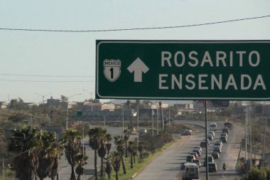 Ensenada, Baja California, Meksika - 14 Aralık 2025: Meksika 'da Tijuana' dan Ensenada Baja California 'ya giden Panoramik Karayolu üzerindeki yol işaretleri yön ve mesafeyi veya çıkışları gösteriyor