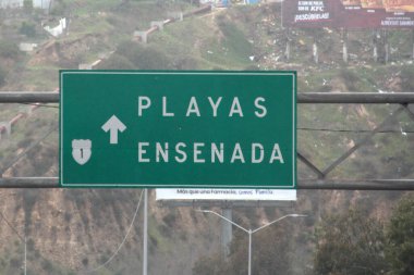 Ensenada, Baja California, Meksika - 14 Aralık 2025: Meksika 'da Tijuana' dan Ensenada Baja California 'ya giden Panoramik Karayolu üzerindeki yol işaretleri yön ve mesafeyi veya çıkışları gösteriyor