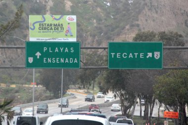 Ensenada, Baja California, Meksika - 14 Aralık 2025: Meksika 'da Tijuana' dan Ensenada Baja California 'ya giden Panoramik Karayolu üzerindeki yol işaretleri yön ve mesafeyi veya çıkışları gösteriyor