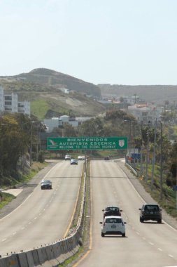 Ensenada, Baja California, Meksika - 14 Aralık 2025: Meksika 'da Tijuana' dan Ensenada Baja California 'ya giden Panoramik Karayolu üzerindeki yol işaretleri yön ve mesafeyi veya çıkışları gösteriyor