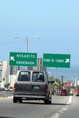 Ensenada, Baja California, Meksika - 14 Aralık 2025: Meksika 'da Tijuana' dan Ensenada Baja California 'ya giden Panoramik Karayolu üzerindeki yol işaretleri yön ve mesafeyi veya çıkışları gösteriyor