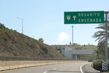 Ensenada, Baja California, Meksika - 14 Aralık 2025: Meksika 'da Tijuana' dan Ensenada Baja California 'ya giden Panoramik Karayolu üzerindeki yol işaretleri yön ve mesafeyi veya çıkışları gösteriyor