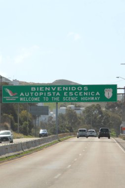 Ensenada, Baja California, Meksika - 14 Aralık 2025: Meksika 'da Tijuana' dan Ensenada Baja California 'ya giden Panoramik Karayolu üzerindeki yol işaretleri yön ve mesafeyi veya çıkışları gösteriyor