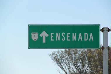 Ensenada, Baja California, Meksika - 14 Aralık 2025: Meksika 'da Tijuana' dan Ensenada Baja California 'ya giden Panoramik Karayolu üzerindeki yol işaretleri yön ve mesafeyi veya çıkışları gösteriyor