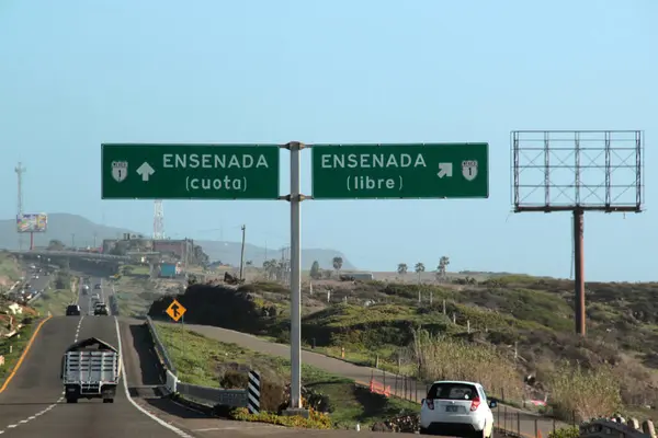Ensenada, Baja California, Meksika - 14 Aralık 2025: Meksika 'da Tijuana' dan Ensenada Baja California 'ya giden Panoramik Karayolu üzerindeki yol işaretleri yön ve mesafeyi veya çıkışları gösteriyor