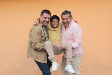 Koyu tenli Latin bir büyükbaba, baba ve oğulun üç nesli Babalar Günü 'nü kutlamak için sevgilerini gösterip birlikte vakit geçirdiler.