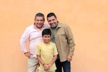 Koyu tenli Latin bir büyükbaba, baba ve oğulun üç nesli Babalar Günü 'nü kutlamak için sevgilerini gösterip birlikte vakit geçirdiler.