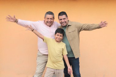 Koyu tenli Latin bir büyükbaba, baba ve oğulun üç nesli Babalar Günü 'nü kutlamak için sevgilerini gösterip birlikte vakit geçirdiler.