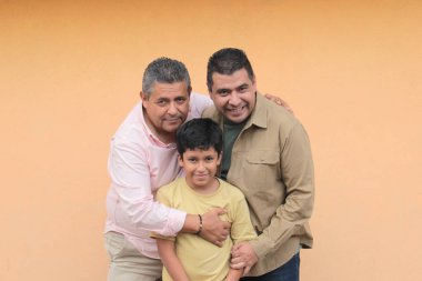 Koyu tenli Latin bir büyükbaba, baba ve oğulun üç nesli Babalar Günü 'nü kutlamak için sevgilerini gösterip birlikte vakit geçirdiler.