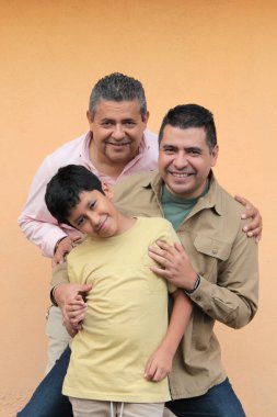 Koyu tenli Latin bir büyükbaba, baba ve oğulun üç nesli Babalar Günü 'nü kutlamak için sevgilerini gösterip birlikte vakit geçirdiler.
