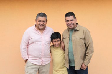 Koyu tenli Latin bir büyükbaba, baba ve oğulun üç nesli Babalar Günü 'nü kutlamak için sevgilerini gösterip birlikte vakit geçirdiler.