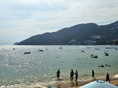 Acapulco, Guerrero, Meksika - 26 Mayıs 2025: Puerto Marques Bay, Acapulco, Guerrero 'nun Pasifik kıyısında, tüm aileye restoranlar ve su aktiviteleri sunar.