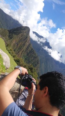 Yetişkin koyu tenli Latin fotoğrafçı Machu Picchu arkeolojik sitesinin fotoğraflarını çekiyor, dünyanın yedi harikasından biri.