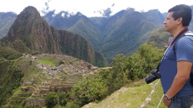 Yetişkin koyu tenli Latin fotoğrafçı Machu Picchu arkeolojik sitesinin fotoğraflarını çekiyor, dünyanın yedi harikasından biri.