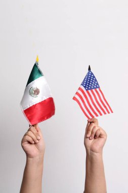 Meksika ve ABD 'nin bayraklarını tutan eller, ülkelerin hükümetleri arasındaki uluslararası ilişkilerin bir temsilcisi olarak