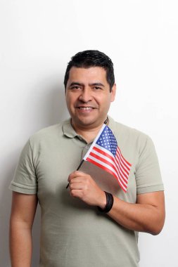 40 yaşındaki esmer tenli Latin bir adam Amerikan bayrağını gösteriyor ve vatandaşlık almak için çalışıyor.