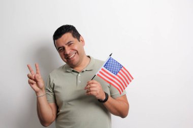 40 yaşındaki esmer tenli Latin bir adam Amerikan bayrağını gösteriyor ve vatandaşlık almak için çalışıyor.