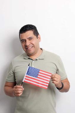 40 yaşındaki esmer tenli Latin bir adam Amerikan bayrağını gösteriyor ve vatandaşlık almak için çalışıyor.